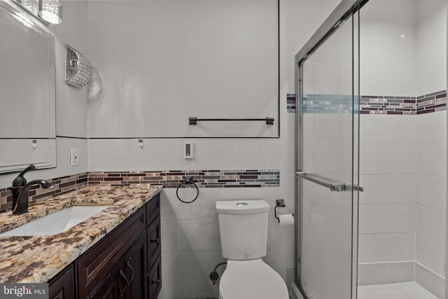 bathroom featuring walk in shower, tile walls, vanity, and toilet