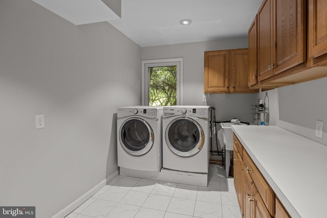 laundry area with separate washer and dryer and cabinets