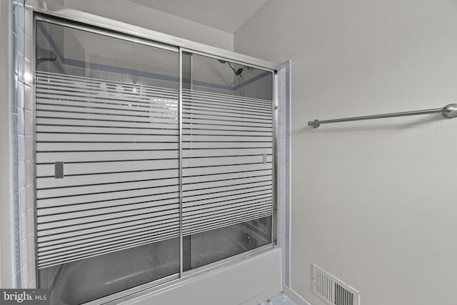 bathroom featuring combined bath / shower with glass door