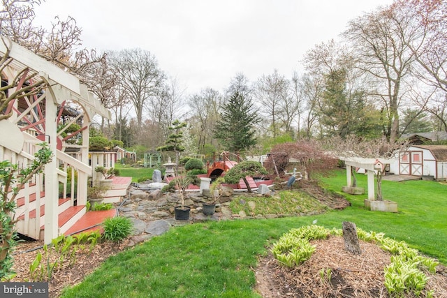 view of yard with a storage shed, a deck, and a patio area