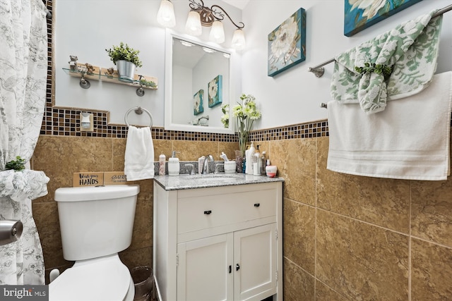 bathroom featuring tile walls, vanity, and toilet