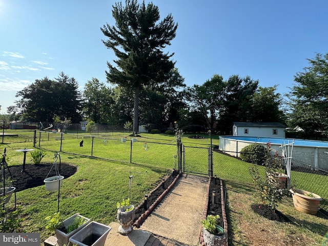 view of yard featuring an outdoor structure and a fenced in pool