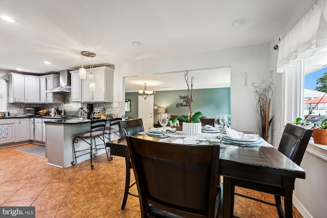 dining space with light tile patterned flooring and a notable chandelier