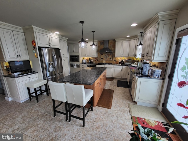 kitchen with pendant lighting, stainless steel appliances, tasteful backsplash, a kitchen island, and wall chimney range hood