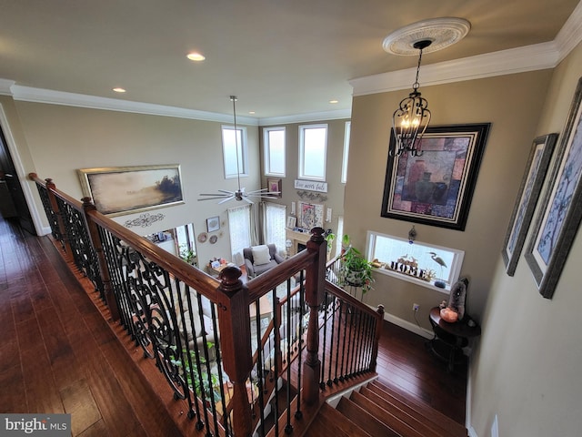 staircase featuring recessed lighting, crown molding, baseboards, wood-type flooring, and an inviting chandelier