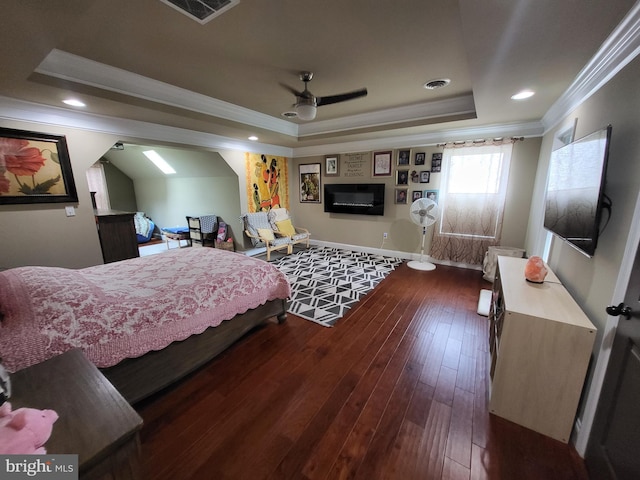 bedroom with dark wood-style floors, crown molding, a raised ceiling, visible vents, and baseboards