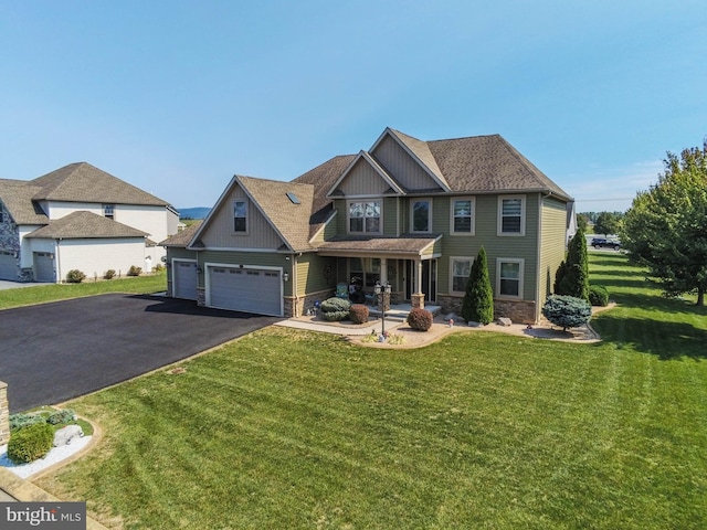 craftsman house with aphalt driveway, a garage, a shingled roof, stone siding, and a front yard