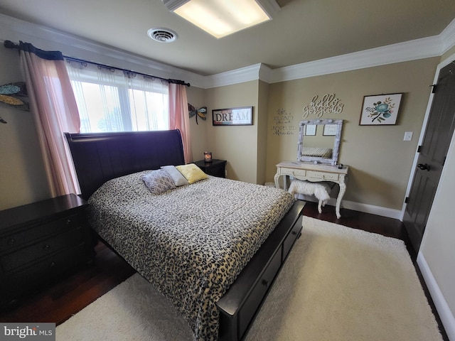 bedroom featuring baseboards, visible vents, dark wood finished floors, and ornamental molding