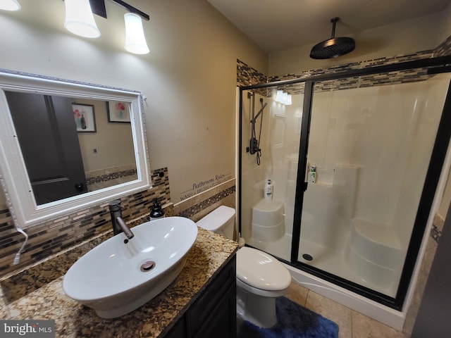 full bath with toilet, vanity, decorative backsplash, tile patterned floors, and a stall shower