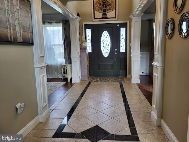 entryway featuring ornate columns and light tile patterned flooring