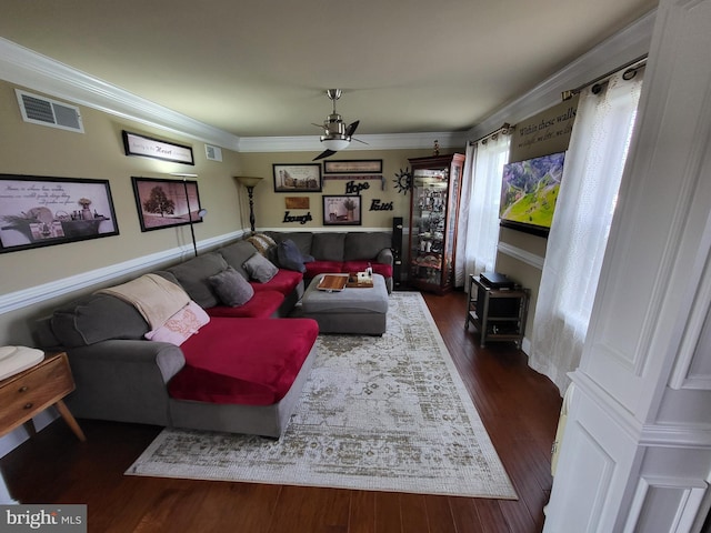 living room featuring ornamental molding, visible vents, dark wood-type flooring, and a ceiling fan