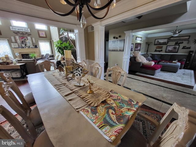 dining area with crown molding, a fireplace, decorative columns, and visible vents