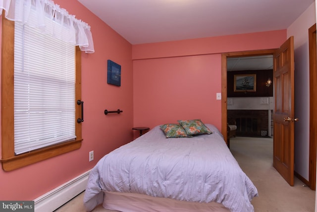 bedroom featuring light colored carpet, a fireplace, and a baseboard radiator