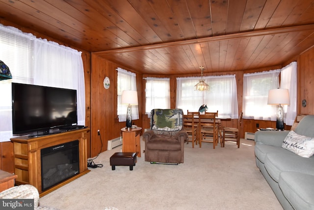 carpeted living area featuring a baseboard heating unit, a glass covered fireplace, wooden walls, and wood ceiling