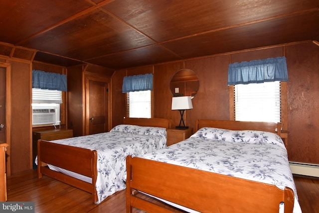 bedroom with wood walls, baseboard heating, dark hardwood / wood-style flooring, and wooden ceiling