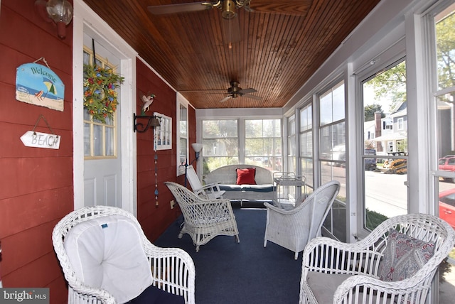 sunroom with ceiling fan and wooden ceiling