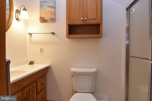 bathroom featuring vanity, toilet, and a shower with shower door