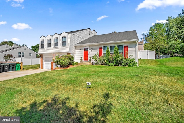 split level home featuring a front yard, driveway, an attached garage, and fence