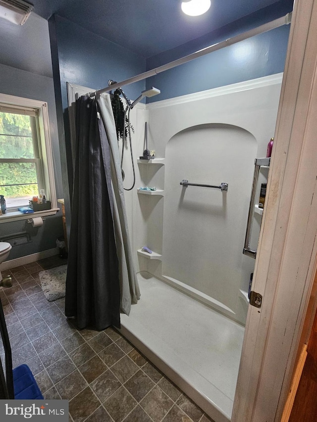 full bathroom with toilet, a stall shower, and visible vents