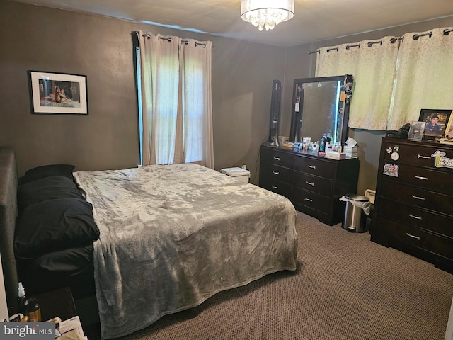 carpeted bedroom featuring an inviting chandelier