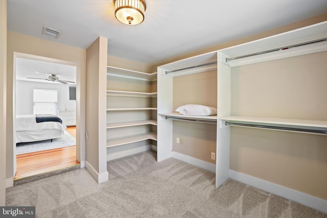 spacious closet featuring light carpet and ceiling fan