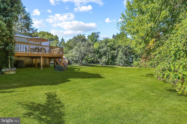 view of yard featuring a wooden deck and central air condition unit