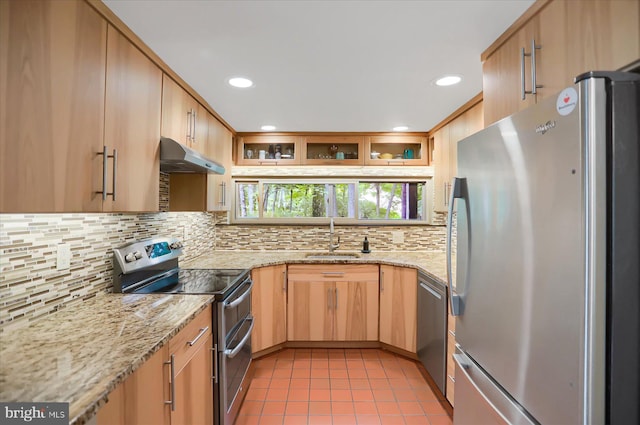 kitchen featuring stainless steel appliances, sink, light stone countertops, and tasteful backsplash