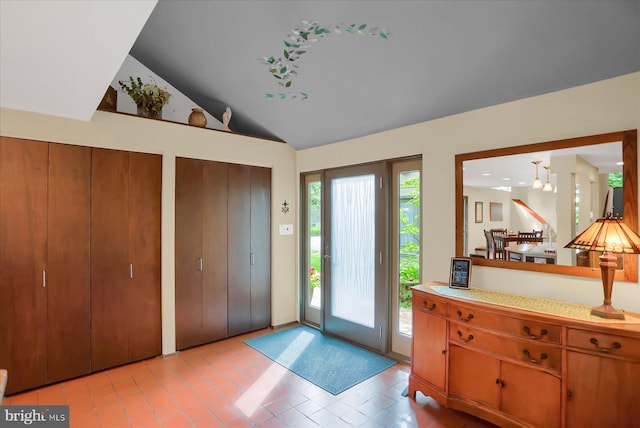 tiled foyer entrance featuring vaulted ceiling