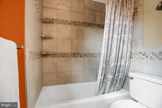 bathroom with tile walls, toilet, and shower / tub combo with curtain