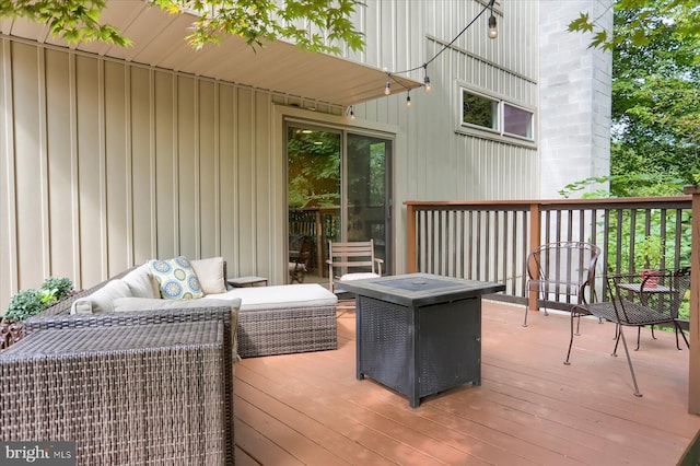 wooden deck featuring an outdoor living space with a fire pit