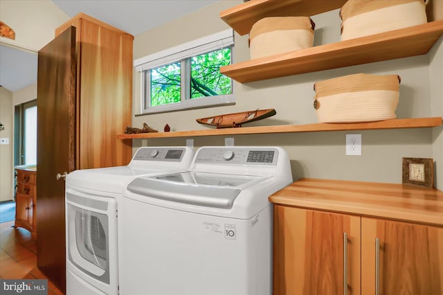 clothes washing area featuring washing machine and dryer and tile patterned floors