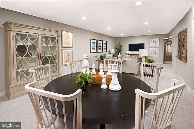 carpeted dining room featuring a textured ceiling