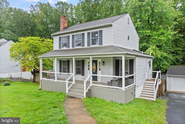 view of front facade with covered porch, a garage, an outdoor structure, and a front yard