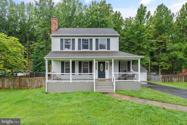 view of front of house with covered porch, an outdoor structure, and a front yard