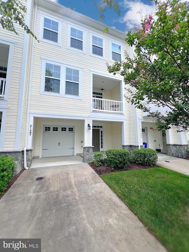 multi unit property featuring a balcony, a front lawn, and a garage