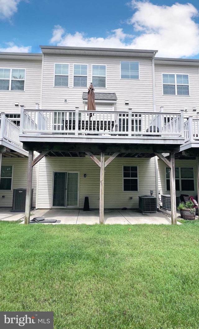 back of house with a patio, a lawn, a wooden deck, and central AC