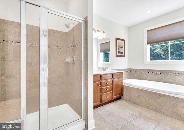 bathroom featuring plus walk in shower, vanity, tile patterned floors, and a healthy amount of sunlight