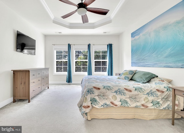 bedroom featuring ceiling fan, a raised ceiling, light carpet, and crown molding