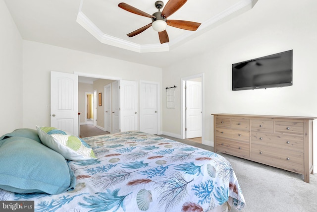 bedroom with a raised ceiling, ornamental molding, ceiling fan, and light colored carpet