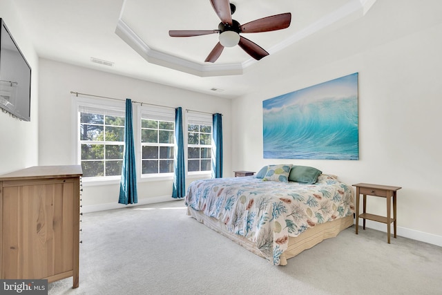 carpeted bedroom featuring ceiling fan, a raised ceiling, and ornamental molding