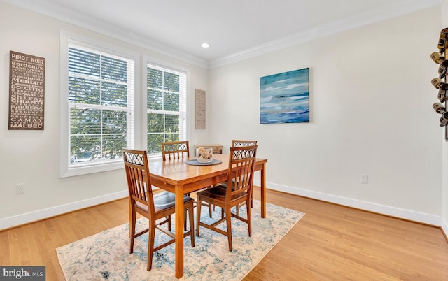 dining area with light hardwood / wood-style floors, plenty of natural light, and ornamental molding