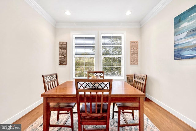 dining space featuring ornamental molding and hardwood / wood-style floors