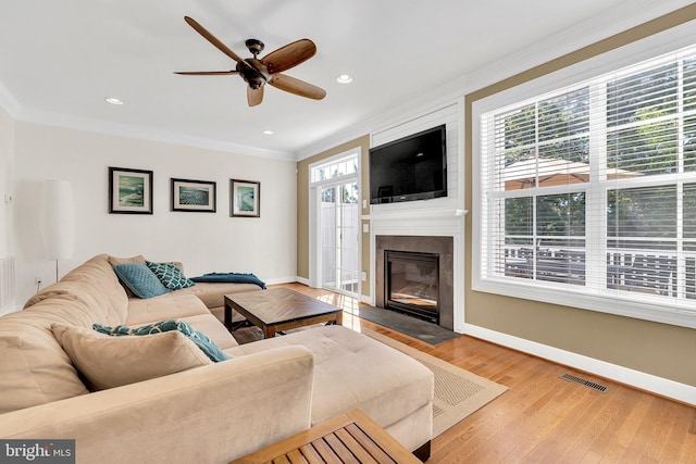 living room featuring ornamental molding, ceiling fan, hardwood / wood-style flooring, and a healthy amount of sunlight