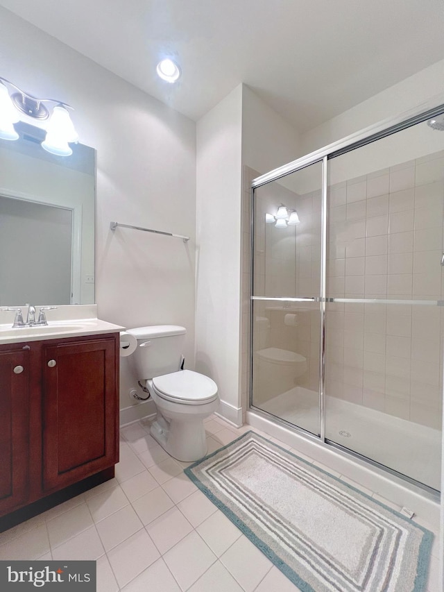 bathroom with vanity, a shower with shower door, toilet, and tile patterned flooring