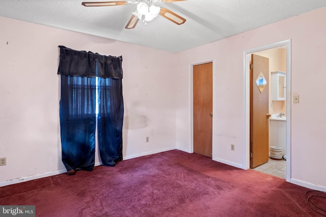 unfurnished bedroom with a textured ceiling, ceiling fan, light carpet, and ensuite bath