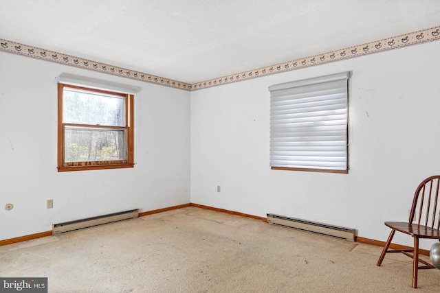 spare room featuring carpet and a baseboard heating unit