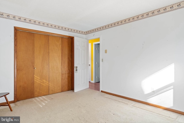 unfurnished bedroom with light colored carpet and a closet