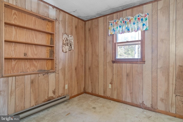 carpeted spare room featuring wood walls, a textured ceiling, and a baseboard radiator