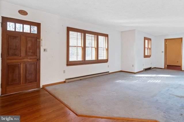 entrance foyer featuring carpet flooring, a baseboard radiator, and a wealth of natural light