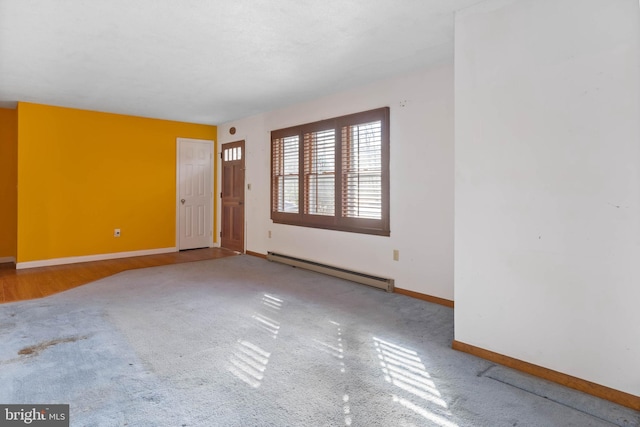 unfurnished room with carpet flooring and a baseboard heating unit